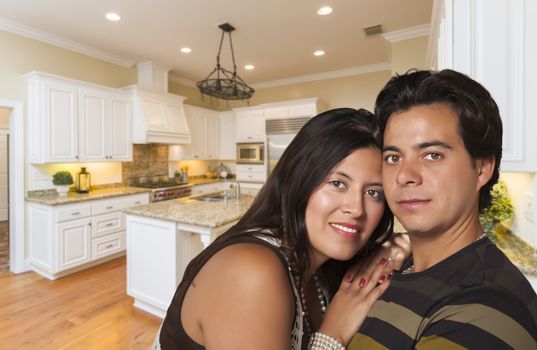 Affectionate Hispanic Couple Inside Custom Kitchen Interior.