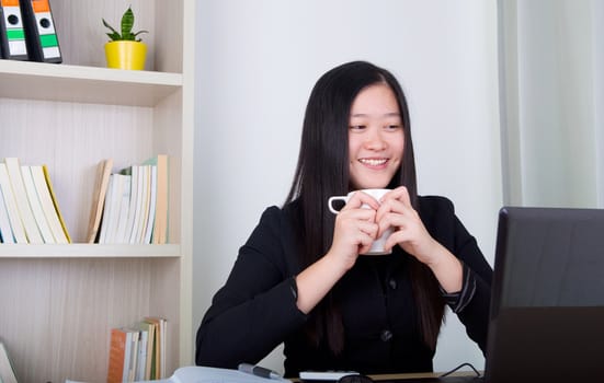 beautiful young business woman drinking coffee in office