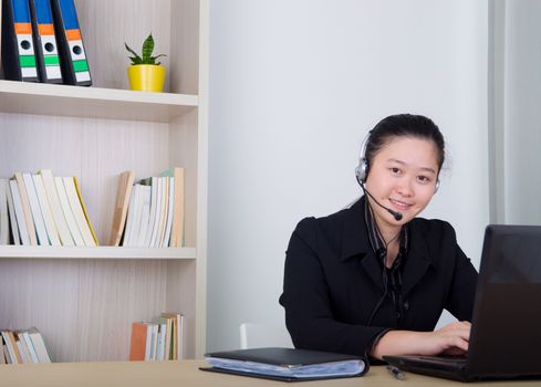 Beautiful asia young business woman with headset and laktop