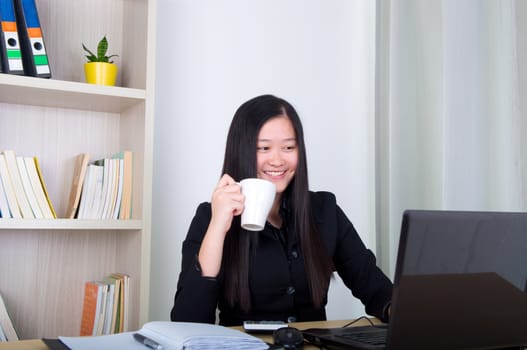 beautiful young business woman drinking coffee in office