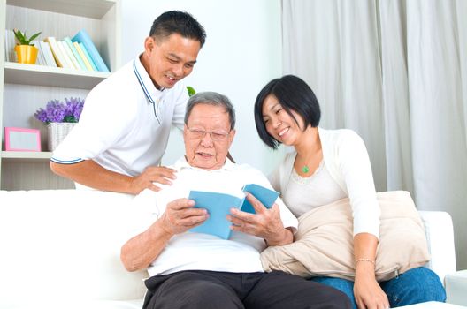 Asian family reading book at home