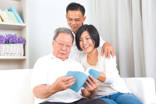 Asian family reading book at home