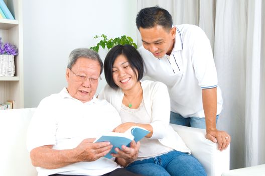 Asian family reading book at home