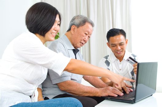 Asian senior man learns to use online internet banking