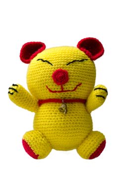 handmade crochet yellow and red cat doll with bell on white background