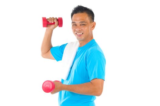 Portrait of fitness man working out with free weights in studio
