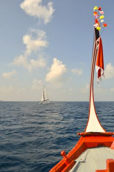 traditional wooden boat head out into deep blue caribbean sea; yacht view.