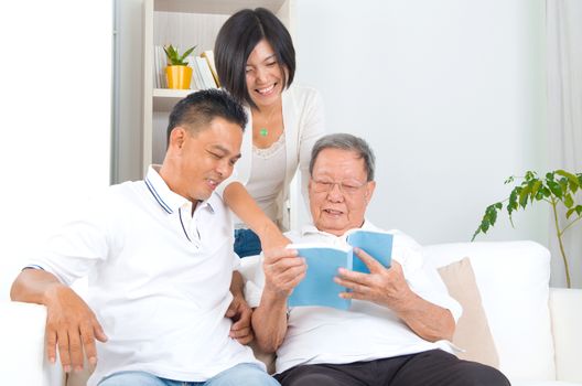 Asian family reading book at home