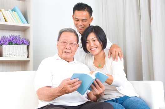 Asian family reading book at home