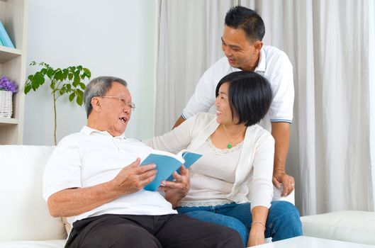 Asian family reading book at home