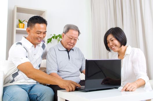 Asian senior man learns to use tablet computer