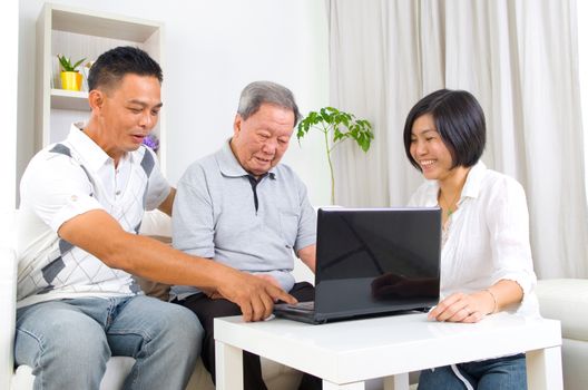 Asian senior man learns to use tablet computer