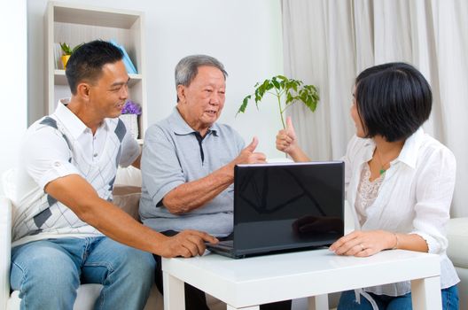 Asian senior man learns to use tablet computer