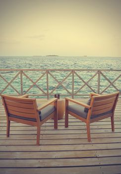 Two beach chairs on wooden floor (Filtered image processed vintage effect)