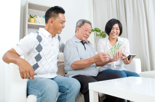 Asian senior man and children calculating money at their home