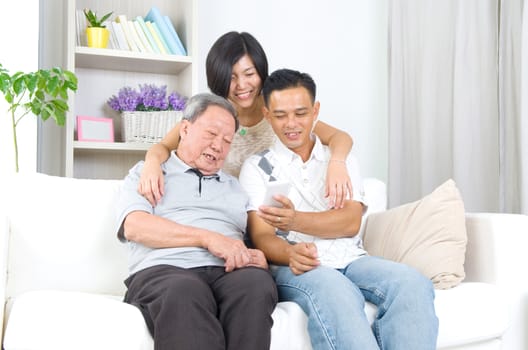 Modern technology, age and people concept. Asian senior man with his daughter and son taking selfie, using smartphone, self photographing.