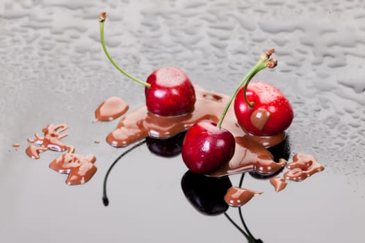 Cherries in chocolate on a glass background