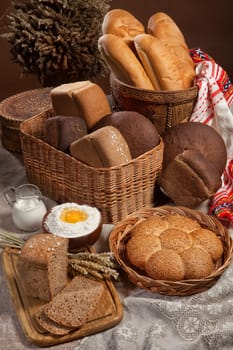 Different kinds of bread, milk and egg on a canvas studio background