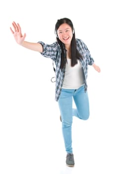 Young woman with headphones listening music and dancing