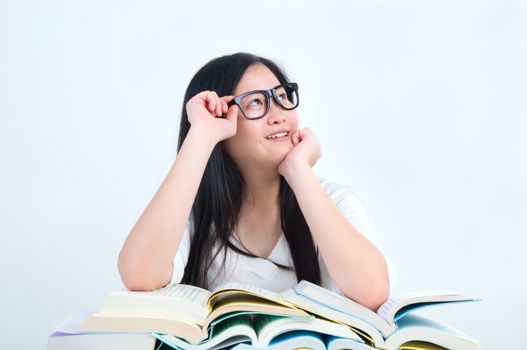 Asian young student girl thinking with book over white background