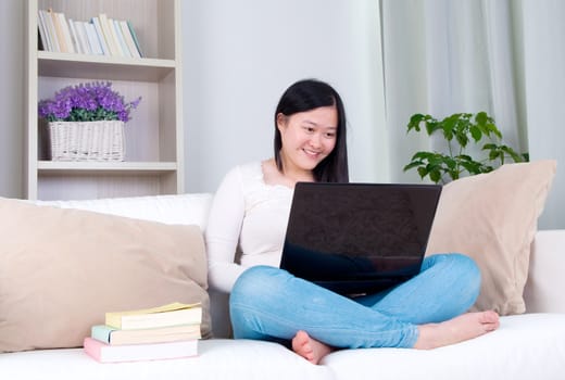 Portrait of attractive Asian girl using laptop. Young woman indoors living lifestyle at home.