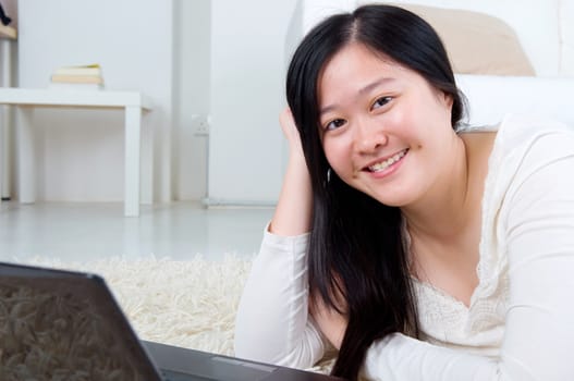 Portrait of attractive Asian girl using laptop. Young woman indoors living lifestyle at home.