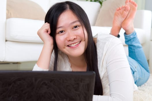 Portrait of attractive Asian girl using laptop. Young woman indoors living lifestyle at home.