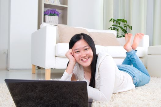 Portrait of attractive Asian girl using laptop. Young woman indoors living lifestyle at home.