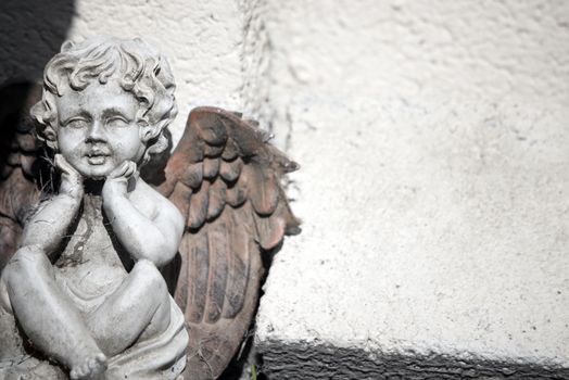 cherub statue against a wall with copy space