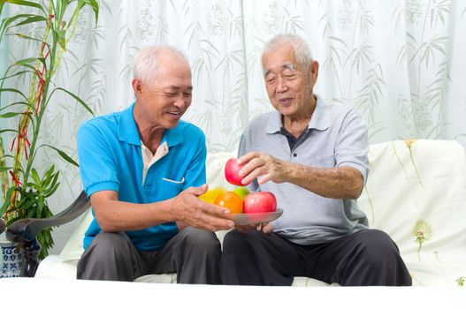 Happy asian family eating healthy fruit.