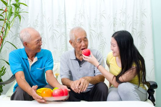 Happy asian family eating healthy fruit.