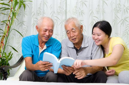 Asian family reading book at home