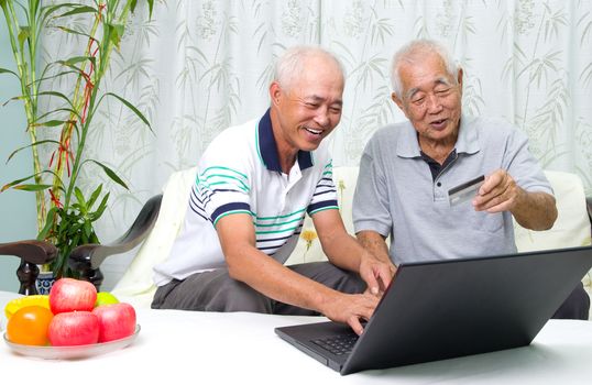 Asian senior man learns to use online internet banking