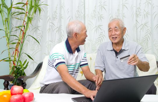 Asian senior man learns to use online internet banking