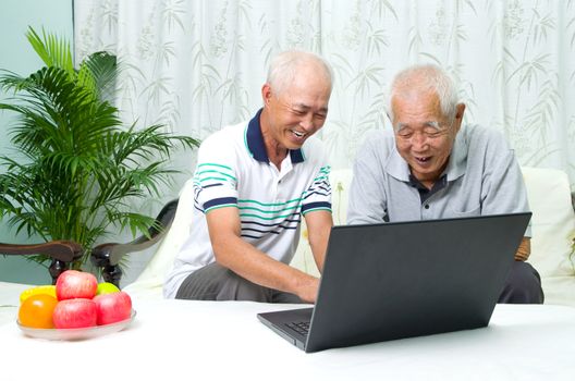Asian senior man learns to use tablet computer