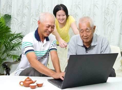 Asian senior man learns to use tablet computer