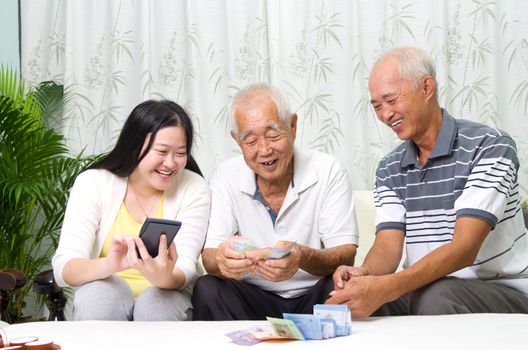 Asian senior man and children calculating money at their home