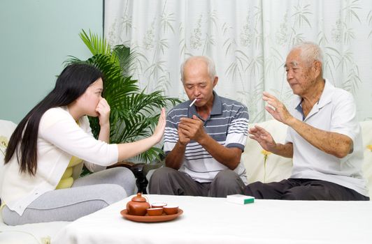 Asian father smoking at home. Unhealthy lifestyle or stop smoking concept photo.