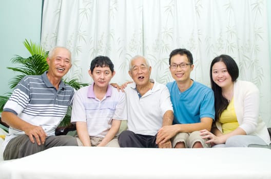 Asian senior father with his adult sons and granddaughter at home. Family living lifestyle.