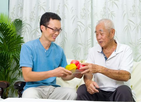 Happy asian family eating healthy fruit.