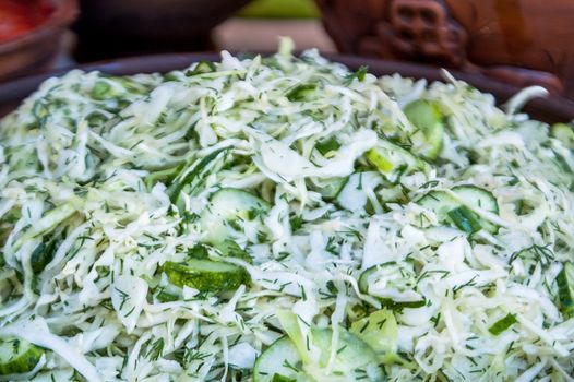 salad from a fresh white cabbage with cucumbers