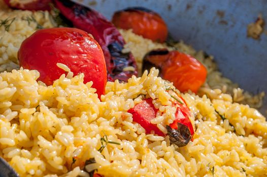 the prepared tasty rice pilaf with vegetables, pepper and tomato
