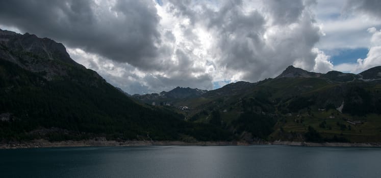 Alpine lake in mountains under clouds and sky in frence vacation