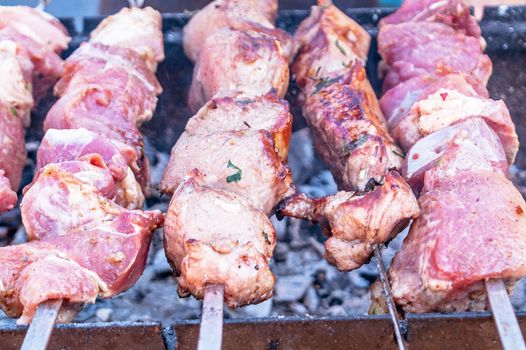 Shish kebab on a skewer fried on open coals of a fire 