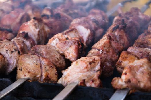 Shish kebab on a skewer fried on open coals of a fire