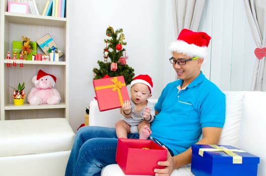 Portrait of happy father and his son in Santa caps on Christmas eve