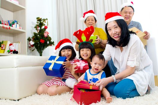 Portrait of happy family members in Santa caps on Christmas eve