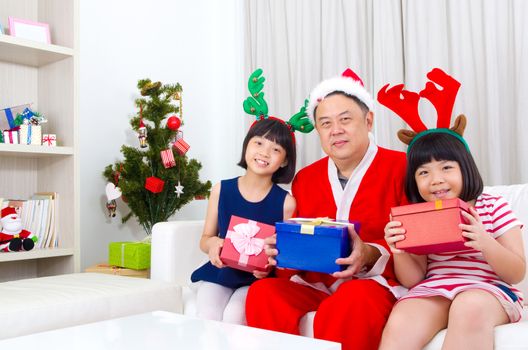 Portrait of happy family members in Santa caps on Christmas eve