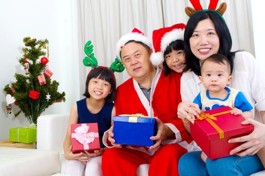 Portrait of happy family members in Santa caps on Christmas eve