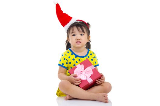 Little Asian girl in Santa hat and Christmas gift box isolated on white